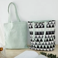 Dual-use canvas tote bag with geometric triangle pattern and green shoulder straps - Black Green Triangle