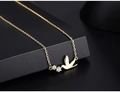 Macro shot of gold bird pendant necklace with sparkling white zircon stone accents - 14K Gold Color (40+5cm)