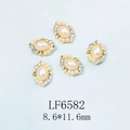 Vue détaillée de perles ovales de 8,6x11,6 mm et strass pour la décoration d'ongles - Faux Perle Blanche Base Rétro Or (6582)
