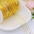 Macro shot of 18K gold plated copper chain on spool for DIY jewelry making - 0.65mm Gold Wire Chain / Thick Silver