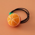 Close-up of handmade crochet orange hair tie with elastic band for girls - Round Orange