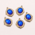 Detail of five gold-framed blue oval glass pendants on light pink gradient background - Blue D (14mm)