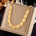 Collana a catena serpente dorata con pendenti geometrici quadrati su cuscino beige - Stile Pezzo di Metallo Rettangolare (N1933)
