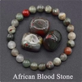 Macro detail of African Blood Stone beaded bracelet and polished raw gemstones - African Blood Stone