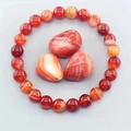 Close-up of red stripe agate beaded bracelet with natural raw gemstone on grey background - Red Stripe Agate