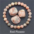 Detail of Red Picasso Jasper beaded bracelet with matching tumbled stones on grey background - Red Picasso Jasper