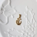 Dettaglio del ciondolo ad ancora in oro 18 carati su vassoio decorativo in ceramica - G07-Mini Ancora