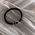 Dettaglio di un elastico per capelli nero con fiocco in argento su tessuto beige - 2# Elastico per Capelli con Fiocco Sottile Argento / Argento