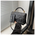 Détail d'un sac à main noir en cuir PU avec poignée tressée et accents métalliques dorés - Noir