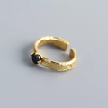 Dettaglio macro di anello in argento dorato con zircone nero e texture effetto stagnola - Aperto Regolabile / Oro