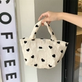 Detalle de bolso de lona con patrón de corazones, textura arrugada y etiqueta tejida - Bolso de Mano Bolsa de Almuerzo
