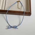 Detailed macro of a foggy blue faceted beaded necklace with an elegant bow pendant - 6# Fog Blue