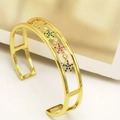 Detail of adjustable gold bangle with star charms inlaid with multicolored zircons - Star Decoration Style