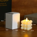 Detail der LED-Würfelkerze mit Maßen 5x5x7cm und passender weißer Geschenkverpackung - Blasen-Würfel-Stil / Cremeweiß