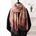 Écharpe à carreaux rose et beige avec pompons sur mannequin dans un décor minimaliste - rose vif
