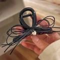 Haarklammer mit silbernem Herzanhänger und Schleife in der Hand präsentiert - Mittel / Schwarz