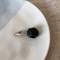 Détail de la pince à cheveux rose en cuir PU noir avec nœud argenté sur une assiette - Barrette Rose Noire