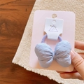 Detail of light blue bow hair tie with textured fabric on purple elastic band - Hair Tie / Blue