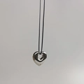 Polished silver hollow heart pendant on a thin black cord necklace close-up view - Silver Hollow Heart (Cord)