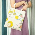 Close-up of cream canvas tote bag featuring vibrant fruit illustrations and geometric patterns - Fruit Series