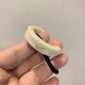 Détail d'un élastique à cheveux noir avec un anneau en C en résine à motif marbré beige - Blanc Cassé