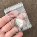 Small clear PVC self-sealing bag for jewelry storage shown with a coin for scale - 100 Pieces / 5*7cm (26 Microns)