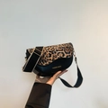Detalle de un bolso silla negro con solapa de leopardo y correa ancha ajustable - Estampado de Leopardo Negro