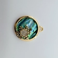 Makroaufnahme eines 18K vergoldeten Schneeflocken-Anhängers mit Abalone-Muschel-Inlay - Schneeflocke (Abalone Muschel) / Gold