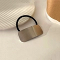 Detail of silver metal rectangle charm on black elastic hair tie with a minimalist design - Silver