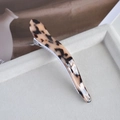 Detailed close-up of a large leopard print acetate hair claw clip on a soft tray - 1# Light Tortoiseshell Curved Horn Clip
