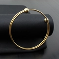 Detail of double-layer gold titanium steel wire bracelet with polished ball ends - Gold