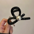 Detalle de la elegante pinza para el pelo negra cruzada con acabado brillante y perla plateada - Negro Brillante (Perla Gris)