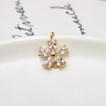 Détail macro d'un pendentif fleur à 5 pétales avec zircons clairs et cuivre doré - Blanc