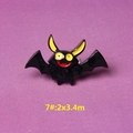 Macro detail of cartoon bat resin accessory with black body and large yellow eyes - Style 7 Black Bat
