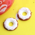 Macro shot of realistic chocolate donut resin accessories with white frosting and pink sprinkles - Donut-Snow White
