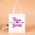 Off-white canvas Team Bride tote bag with pink lettering for bachelorette party favors - Team Bride Pink Heart Arrow Logo