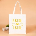 White canvas tote bag with golden Bride Tribe print for bridesmaid gifts and bridal showers - Yellow Heart Arrow Bride