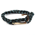 Close-up of woven nautical bracelet featuring a golden fish hook clasp and blue rope - Black/Blue White Dots-Gold Fishhook