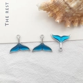 Three blue enamel whale tail pendants for DIY jewelry making on soft fabric background - 1pc Silver Mermaid Tail
