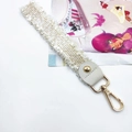 Detail of off-white lace fringe strap with white leather and gold metal lobster clasp - White