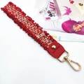 Detail of red tweed woven strap with gold lobster clasp and fringed edge texture - Red