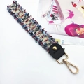 Close-up of colorful tweed woven bag strap with golden lobster clasp and fringe detail - Pale Blue