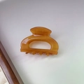 Vista superior detallada de una pequeña pinza para el pelo ámbar sobre fondo blanco - Caramelo