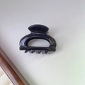 Detail view of a small black acetate hair claw clip with golden France Handmade logo - 7#Black