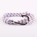 Dettaglio del bracciale in corda nautica con gancio a forma di pesce su sfondo rosa - Rosso/Bianco/Blu