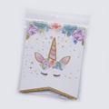 Close-up of unicorn birthday banner card with gold glitter and floral details in polybag - Glitter Unicorn