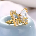 Elegante anello a farfalla dorato con ali di cristallo e zirconi su supporto azzurro - Bianco