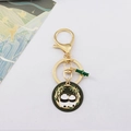 Detailed close-up of a panda keychain with golden metal finish and green bamboo charm - Round Panda Plate Style (3)