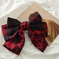Detail of satin red leopard print bow hair clip showing fabric texture and drape - Red Leopard