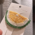 Handmade crochet lemon slice hair clip with vibrant yellow and green yarn texture - Lemon
